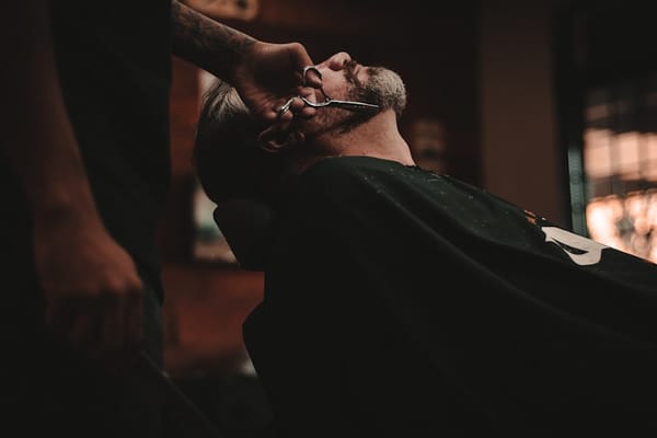 Barber trimming a beard in Colombia — personal care services are excellent and affordable