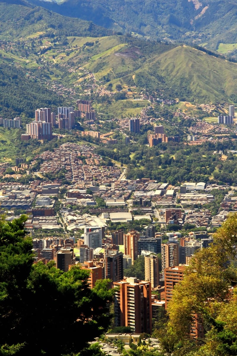 Vista aérea de Medellín con edificios y montañas al fondo